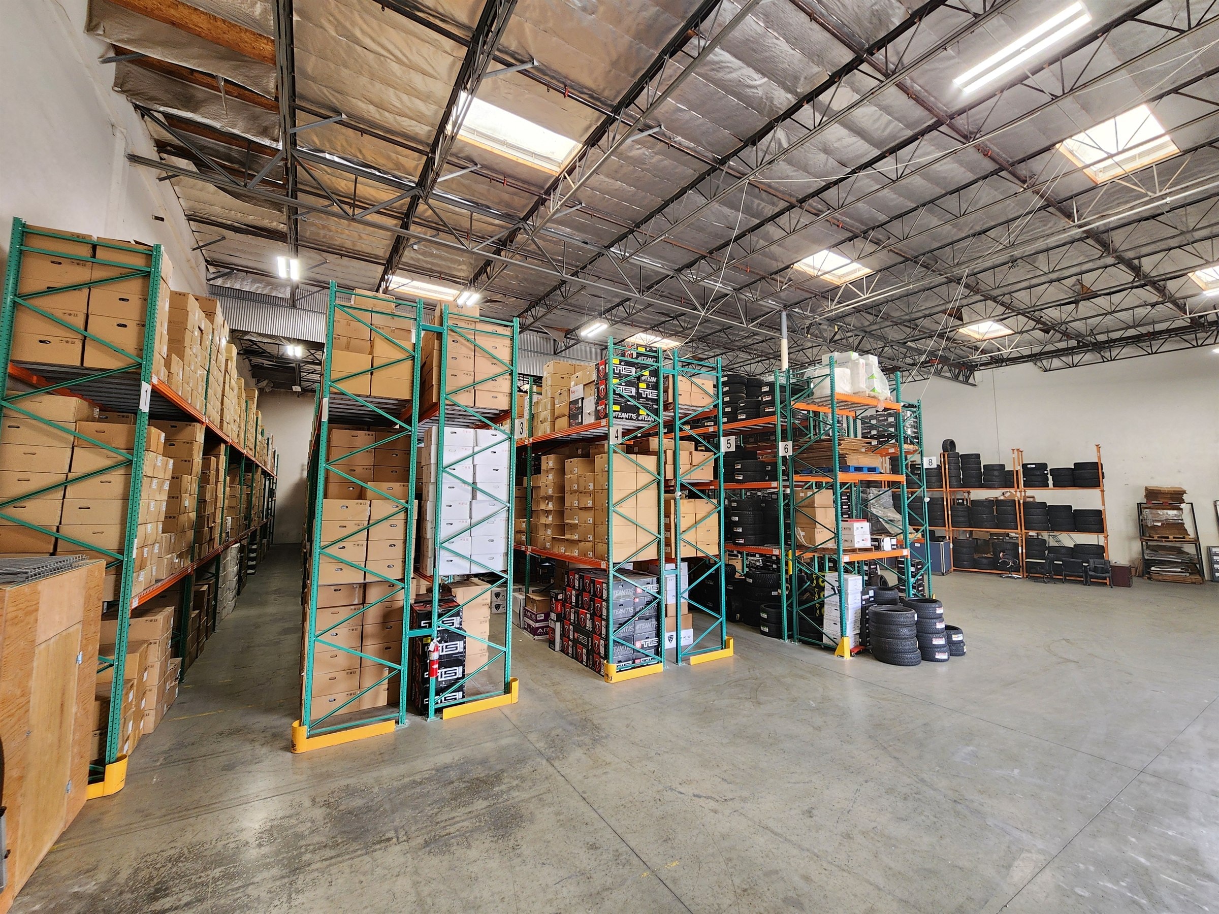 Inside the BHY Tire & Wheel warehouse in Mira Loma — racks stacked with wheels and tires in stock